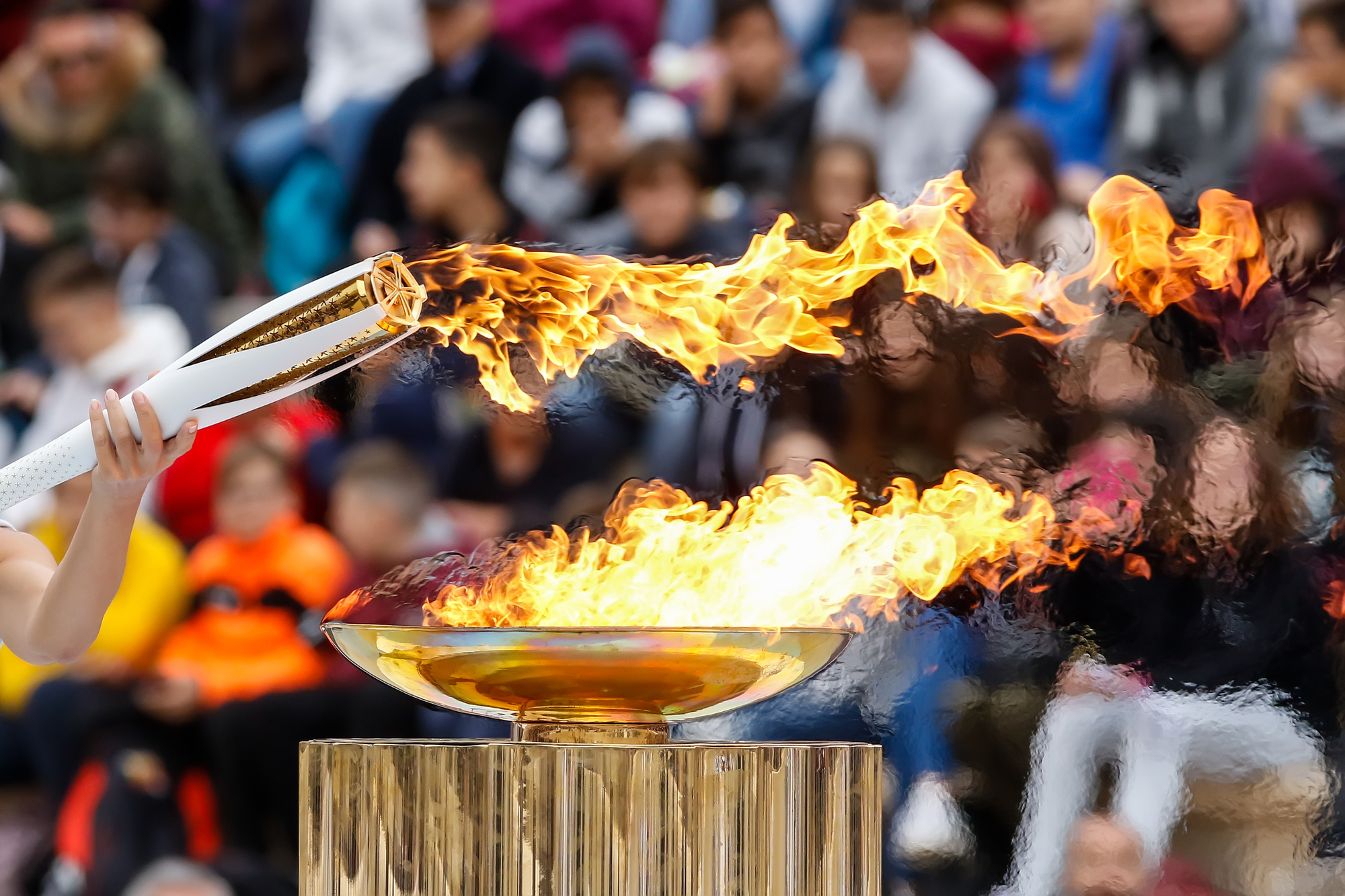 Факел начал игру. Олимпийский огонь 2022. Зажжение олимпийского огня в Сочи 2014. Факел олимпийского огня. Традиция зажжения олимпийского огня.
